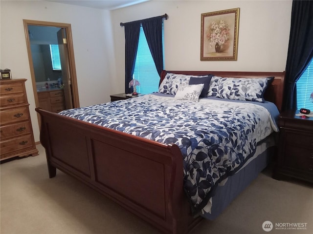 bedroom with ensuite bath and light carpet