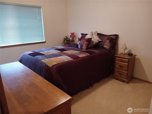 bedroom with light colored carpet and baseboards