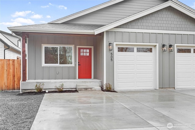 view of front of house with a garage, a shingled roof, driveway, and fence