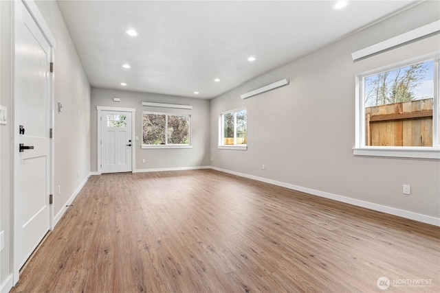 unfurnished living room featuring recessed lighting, light wood-style flooring, and baseboards