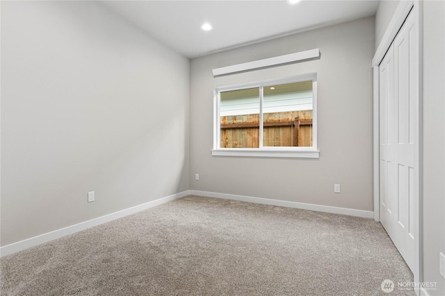 unfurnished bedroom with a closet, recessed lighting, baseboards, and carpet floors