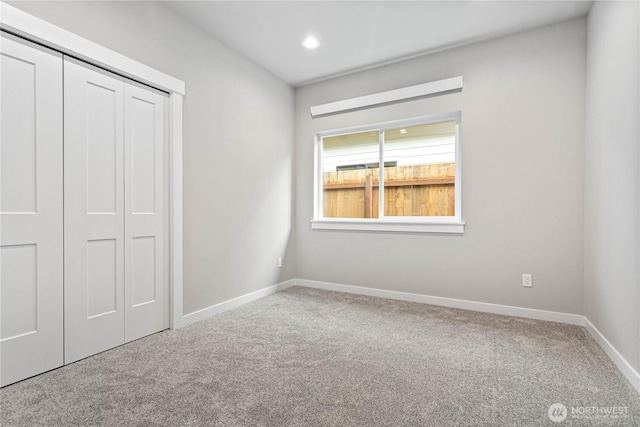 unfurnished bedroom with recessed lighting, baseboards, a closet, and carpet floors