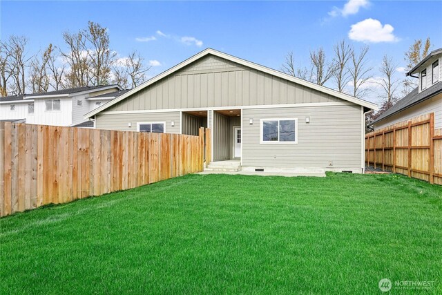 rear view of house with a yard and fence