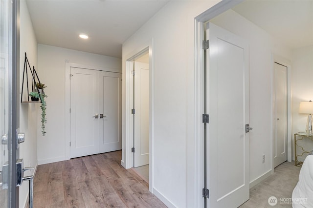 corridor with recessed lighting, light wood-type flooring, and baseboards