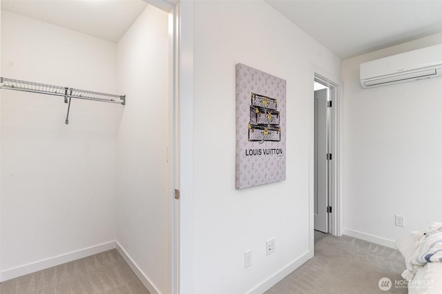 hall featuring light colored carpet, a wall mounted air conditioner, and baseboards