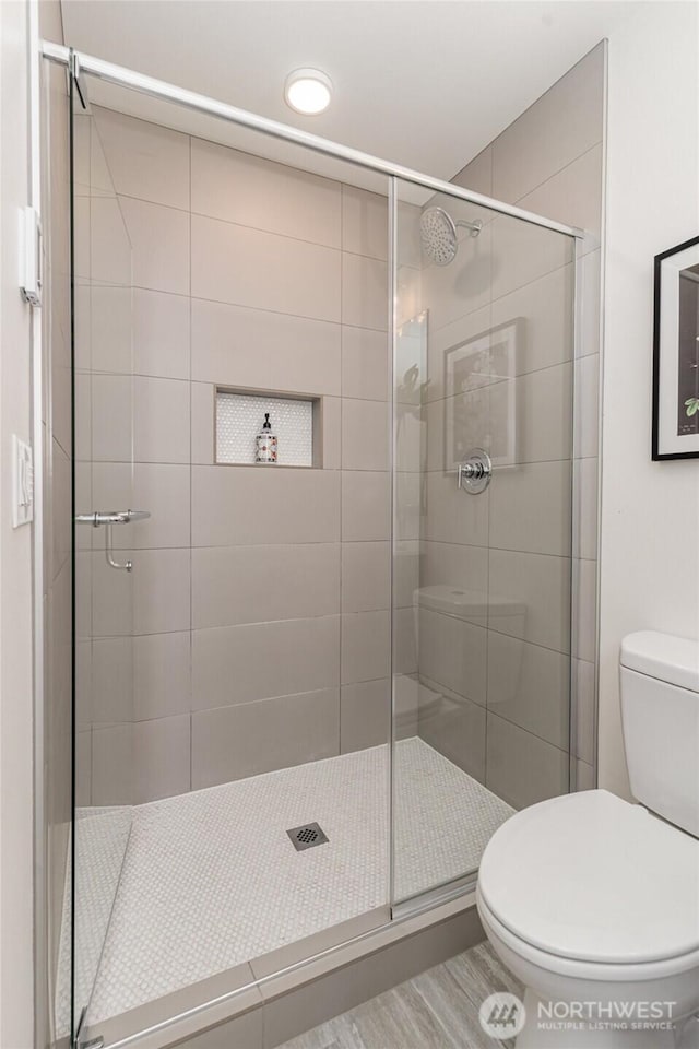 full bathroom with a stall shower and toilet