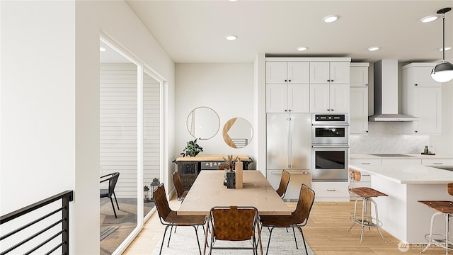 dining space with recessed lighting and light wood-type flooring