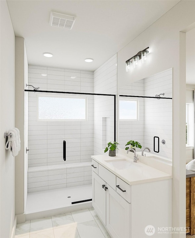 full bathroom with vanity, a shower stall, visible vents, and a wealth of natural light