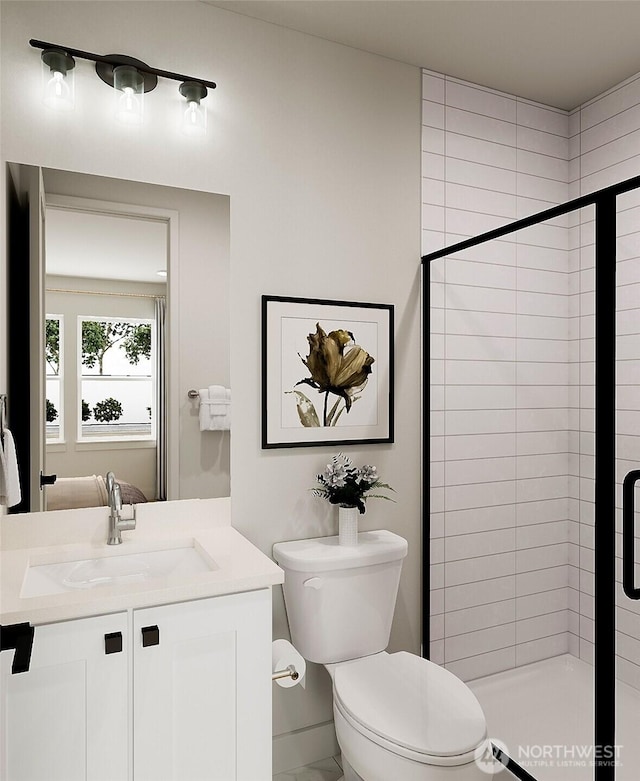 bathroom with vanity, a shower stall, and toilet