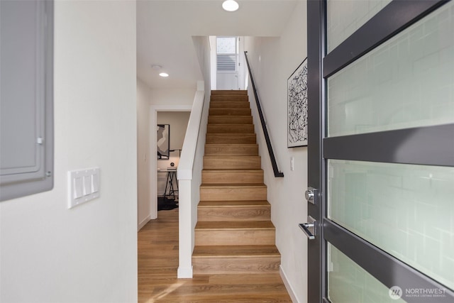 staircase with recessed lighting, baseboards, and wood finished floors