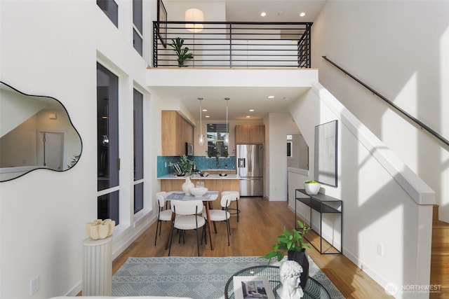 dining room featuring stairs, a high ceiling, recessed lighting, and wood finished floors