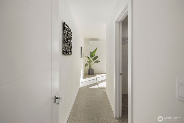 hallway featuring baseboards, carpet floors, and a wall unit AC