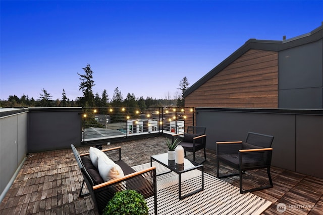 patio terrace at dusk with an outdoor living space and a balcony