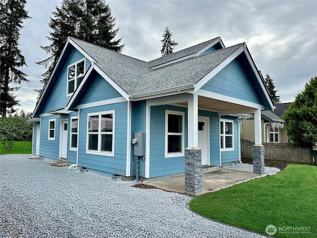 view of front of property with crawl space, roof with shingles, a front lawn, and fence