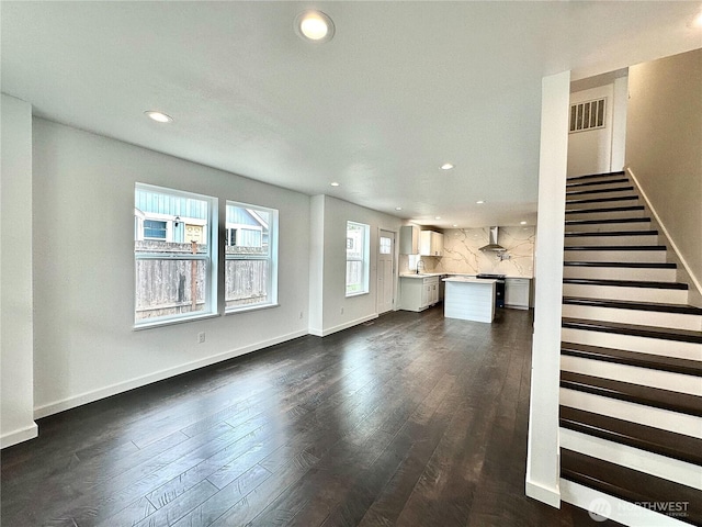 unfurnished living room with visible vents, recessed lighting, and dark wood-style flooring