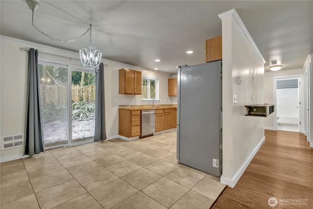 kitchen with visible vents, ornamental molding, light countertops, appliances with stainless steel finishes, and a chandelier