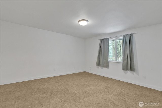 unfurnished room with baseboards