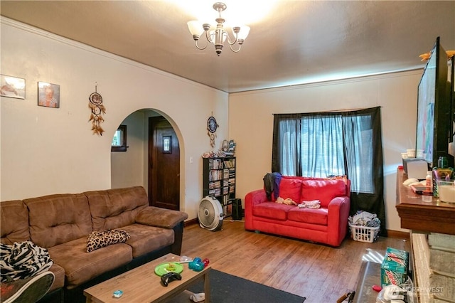 living area featuring an inviting chandelier, wood finished floors, arched walkways, and a wealth of natural light