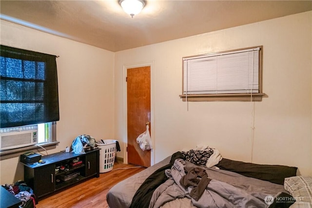 bedroom featuring cooling unit and wood finished floors