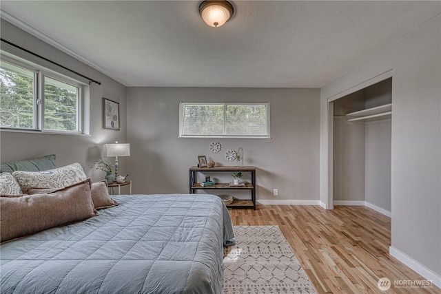 bedroom featuring a closet, baseboards, and wood finished floors