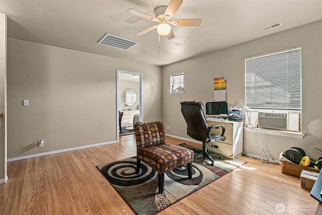 home office with wood finished floors, cooling unit, a ceiling fan, and visible vents