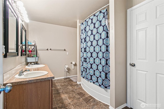 full bathroom featuring double vanity, shower / tub combo with curtain, baseboards, and a sink