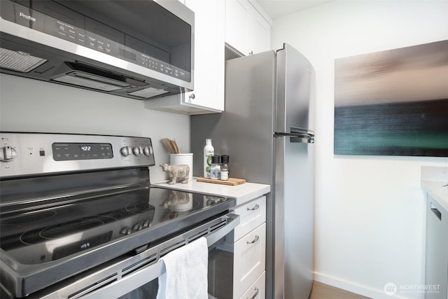 kitchen with light countertops, white cabinets, and appliances with stainless steel finishes