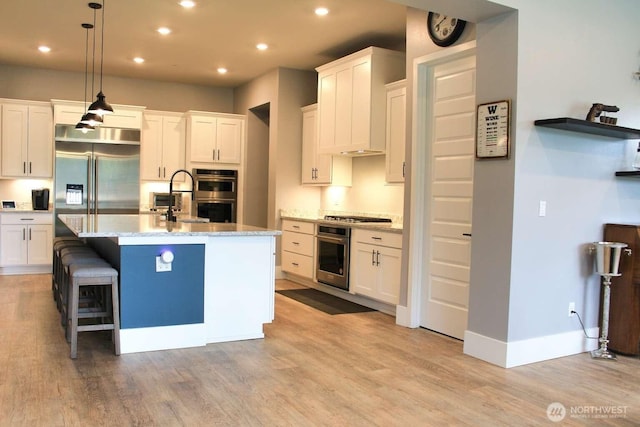 kitchen featuring stainless steel appliances, white cabinetry, and light wood finished floors