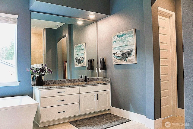 full bathroom with vanity and baseboards