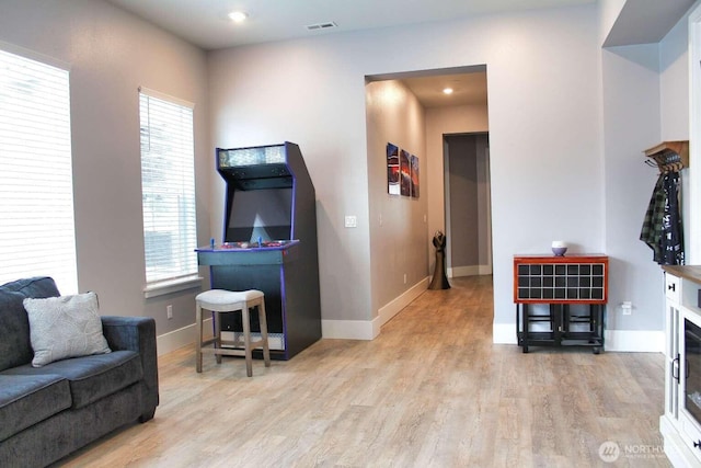 living area with visible vents, wood finished floors, and baseboards