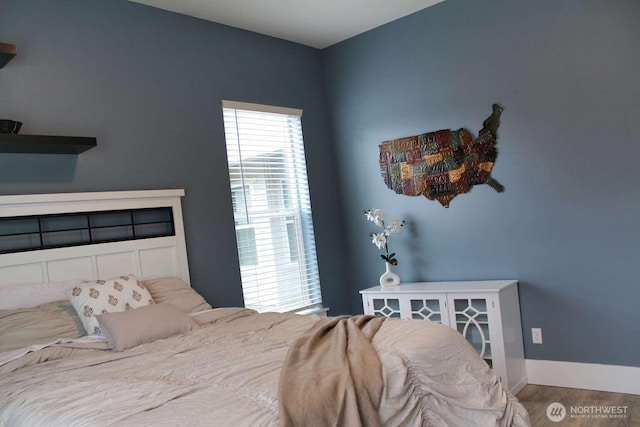 bedroom featuring baseboards and wood finished floors