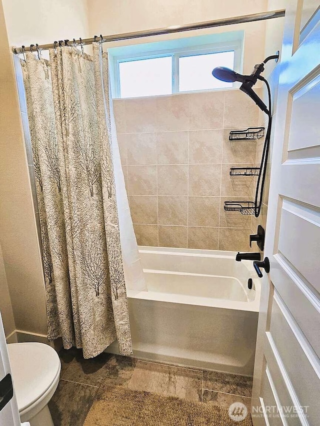 bathroom with toilet and shower / bath combo with shower curtain