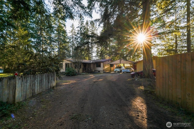 view of front facade featuring a detached carport, fence, and driveway