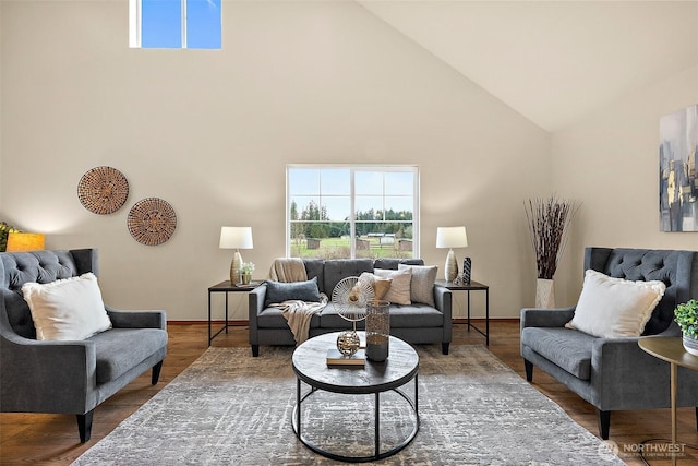 living room with baseboards, high vaulted ceiling, and wood finished floors