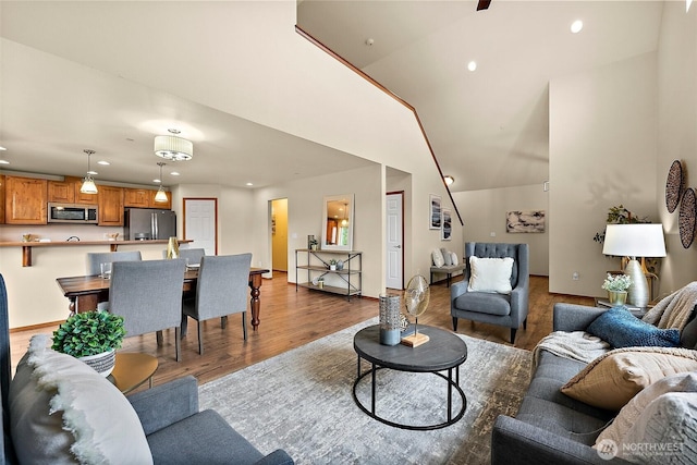 living room with recessed lighting, baseboards, dark wood-type flooring, and a towering ceiling