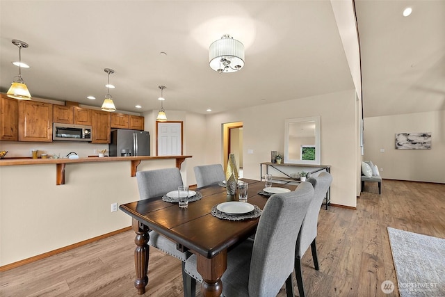 dining room with recessed lighting, baseboards, and light wood-style flooring