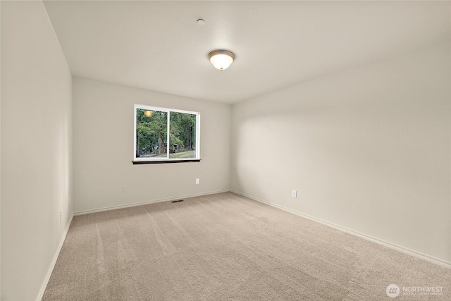 empty room with baseboards and light carpet