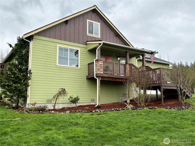 rear view of property featuring board and batten siding and a yard