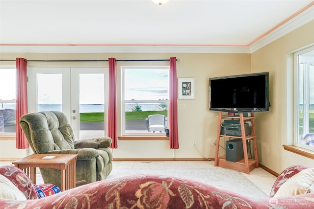 living area with french doors, ornamental molding, a wealth of natural light, and tile patterned flooring