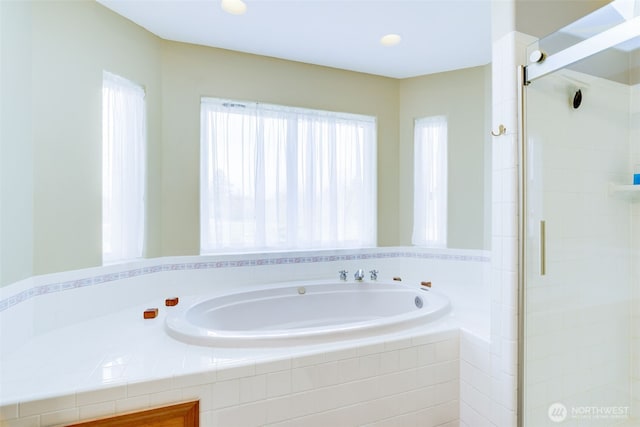 full bathroom with a shower stall and a bath