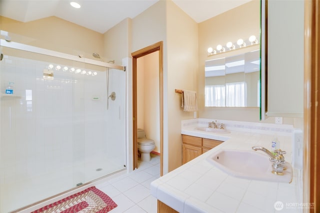full bathroom featuring a stall shower, a sink, and toilet