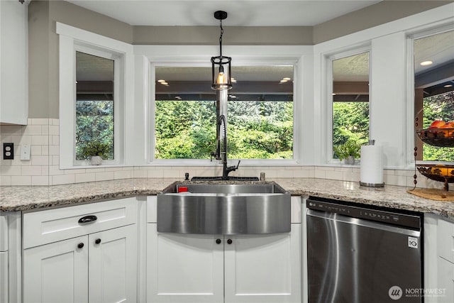 kitchen with stainless steel dishwasher, a wealth of natural light, backsplash, and a sink