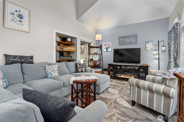 carpeted living room with high vaulted ceiling