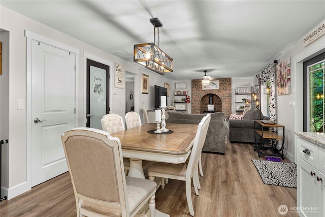 dining space featuring baseboards and light wood-style flooring