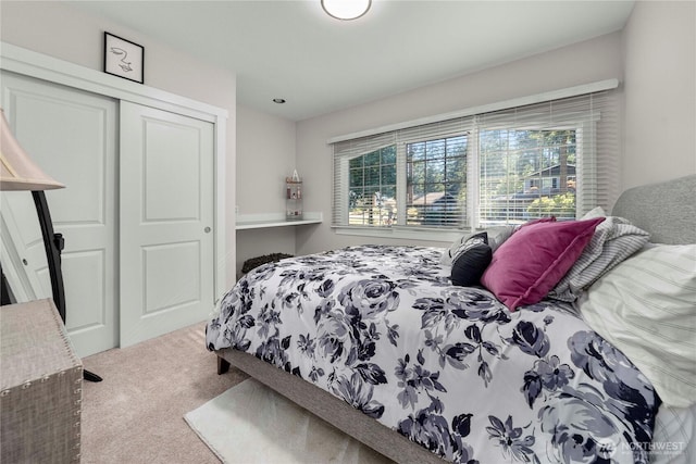 carpeted bedroom featuring multiple windows and a closet