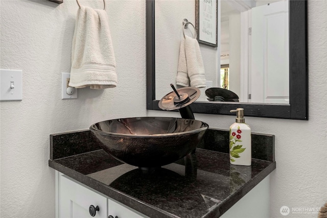 bathroom featuring vanity and a textured wall