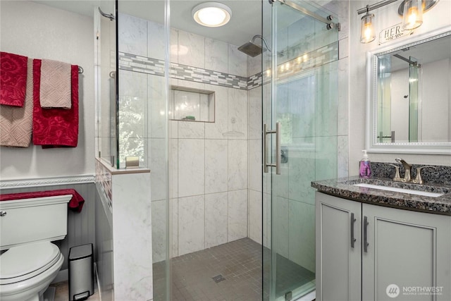 full bathroom with vanity, toilet, and a shower stall