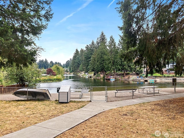 view of home's community featuring a gate, fence, and a water view