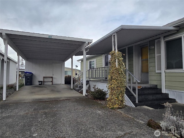 view of parking featuring entry steps, a carport, and driveway