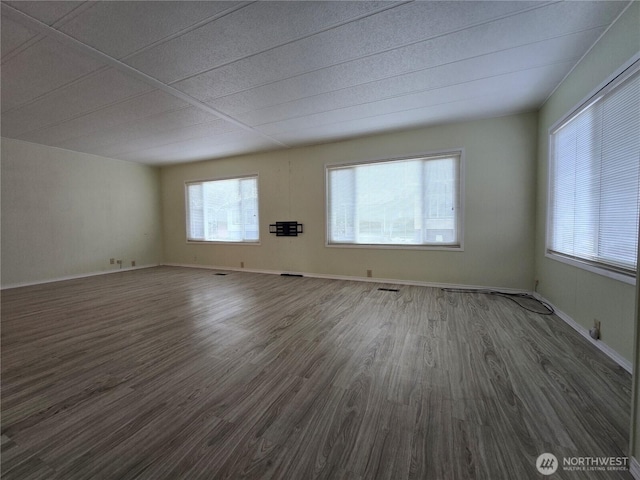 empty room featuring dark wood-type flooring and baseboards